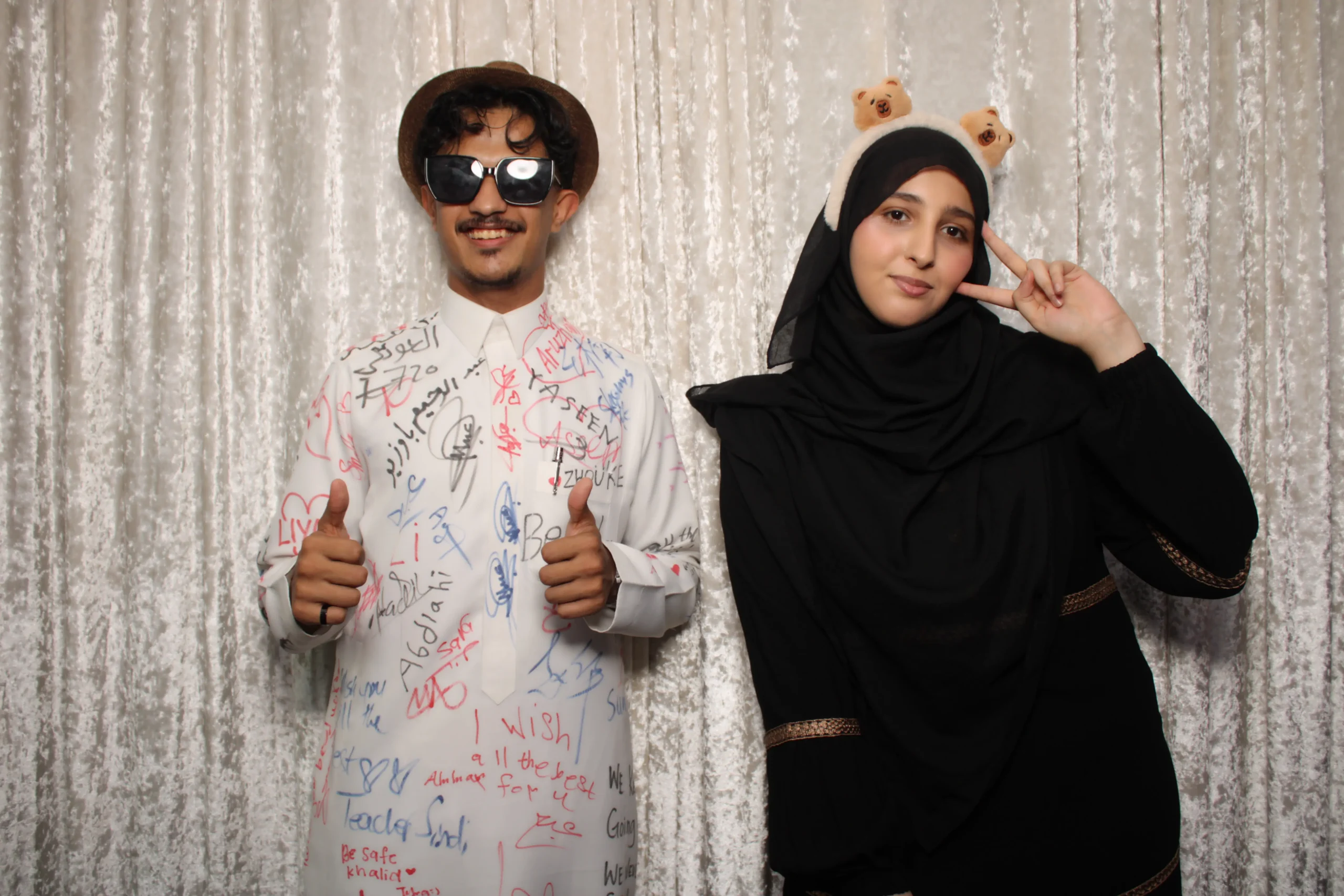 طالب سعودي يرفع إبهامه في فعالية Big Ben Academy ماليزيا مع زميلته — بيئة اجتماعية مرحة لرفع IELTS
